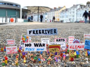 Spielfiguren mit Plakaten mit politischen und sozialen Anliegen
