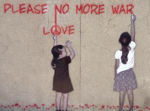 Ein Street-Art Graffiti mit zwei Mädchen, die einen Schriftzug an eine Wand sprühen