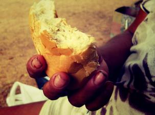 Eine Hand, die ein Stück Brot hält 