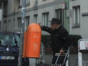 Ein Mann sucht in einem Mülleimer nach Pfandflaschen