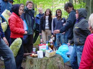 Eine Gruppe junger Menschen bei einem Vortrag im Wald