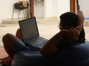 Mann sitzt und arbeitet an seinem PC