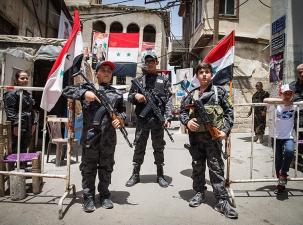 Syrische Kindersoldaten mit Waffen und Fahnen