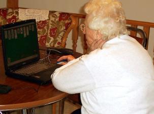 Eine Seniorin vor einem PC sitzend