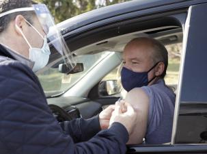 Die Corona-Impfung wird einem Autofahrer verabreicht