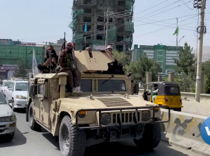 Eine Gruppe Taliban Kämpfer auf einem gepanzerten Wagen mit Waffen