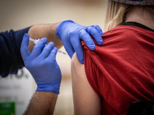 Eine Person erhält eine Covid-Impfung in die Schulter