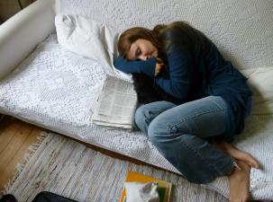Eine junge Frau schläft auf einer Couch