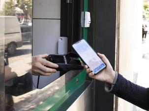 Ein Mensch bezahlt mit einer Handy-App an einem Essensstand