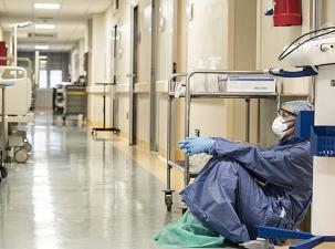 Ein Krankenhaus-Mitarbeiter während der Pandemie erschöpft in einem Krankenhaus