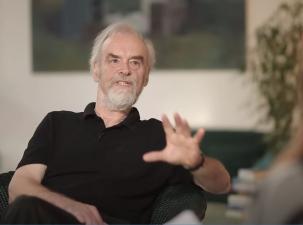 Rainer Mausfeld bei einem Interview sitzend