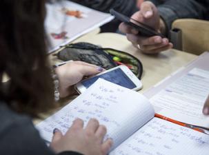 Zwei Kinder mit Handys im Unterricht