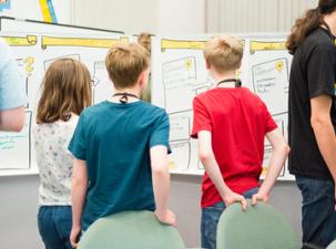 Eine Gruppe Kinder vor einer Pinnwand