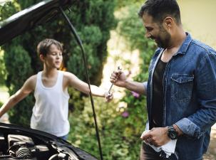 Ein Vater und Sohn bei der Reperatur eines Autos