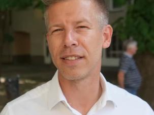 Der ungarische Politiker P&eacute;ter Magyar wird von G&aacute;bor R&eacute;v&eacute;sz interviewt, nachdem er am 20. Mai 2024 im Vorfeld der Europawahlen in Ungarn bei einer Wahlkampfveranstaltung in Csongr&aacute;d eine Rede gehalten hat. - Mann mit kurzem, blonden Haar und einem wei&szlig;en Hemd, steht im Freien vor einem unscharfen Hintergrund.