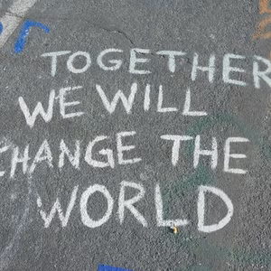 In wei&szlig;er Schrift steht auf dem Asphalt: "Zusammen k&ouml;nnen wir alles &auml;ndern."