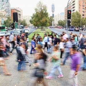 Viele Menschen &uuml;berqueren eine Stra&szlig;e