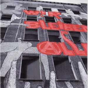 Ein Magazincover mit dem Titel "Synapse", das ein Graffiti mit der Aufschrift "WIR BLEIBEN ALLE" zeigt, umgeben von Fenstern.