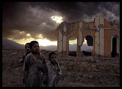 Afghanische Kinder vor einem zerstörten Haus