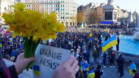 Protest in der Ukraine mit vielen Menschen und einem Schild, worauf steht "Ukraine resist".