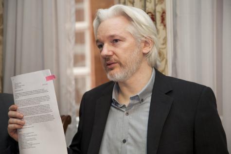 Julian Assange mit Dokumenten in der Hand
