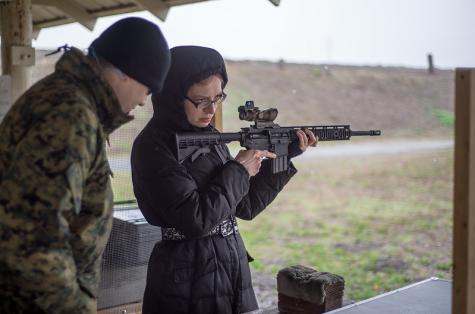 Eine Frau auf einem Waffenstand mit einem Ausbilder