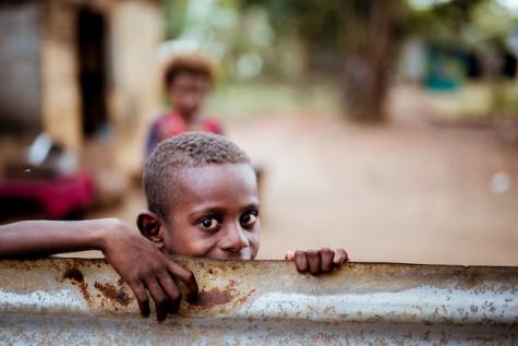 Man sieht einen kleinen afrikanischen Jungen auf dem Bild. Internationales Engagement für eine faire Welt steht dafür, dass alle Menschen, dass Recht auf ausreichend Nahrung sowie einen lebenswerten Lebensraum haben.