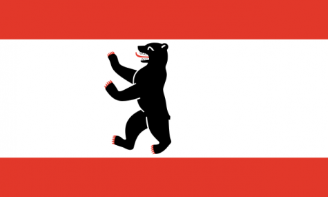 Die Fahne von Berlin zeigt einen schwarzen Bären vor weissem Hintergrund mit je einem roten Streifen oben und unten. Wikimedia Commons