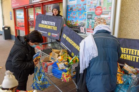 Eine Aktion, bei der vor einem Supermarkt gerettete Lebensmittel verteilt werden