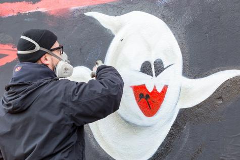 Ein Graffiti-Spr&uuml;her bei der Anfertigung eines Bildes