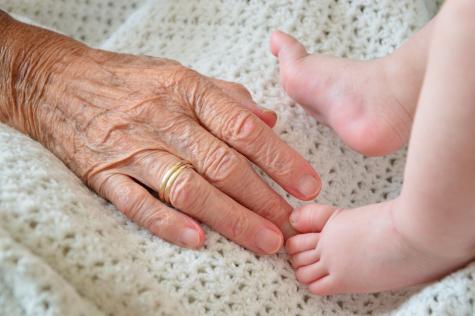 Seniorenhand und Babyf&uuml;&szlig;e