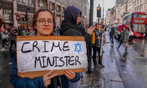 Eine Demonstratin mit einem Schild gegen Netanjahu 