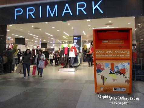 Eine Kleidertonne vor einem Primark-Geschäft 