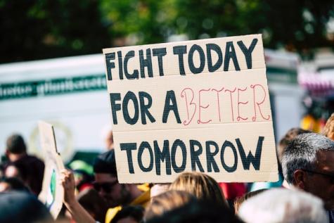 Schild mit der Aufschrift "Fight today for a better tomorrow" bei einem Protest - als Inspiration für Menschen, die etwas verändern wollen und selbst Beispiele für Vorbilder werden wollen. 