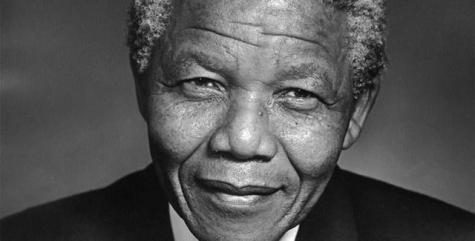 Eine Schwarz-Weiß-Fotografie von Nelson Mandela in einem schwarzen Anzug. 