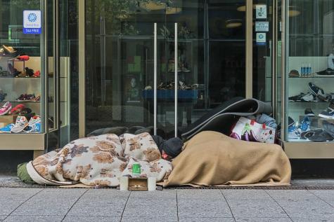 Zwei obdachlose Menschen schlafen vor einem Geschäft