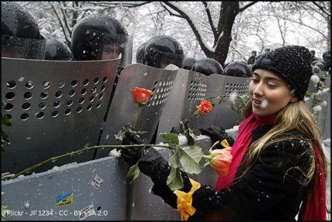 Mädchen verteilt Blumen an Soldaten im Russland-Ukraine-Krieg 2014. Ein Beispiel für die Umsetzung von Gewaltfreiheit im Krieg.