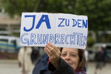 Eine Frau mit einem Schild f&uuml;r mehr Grundrechte auf einer Demo