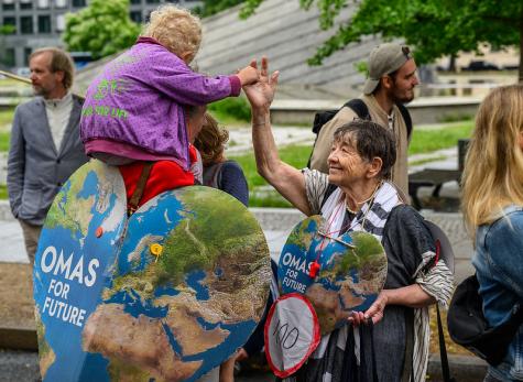 Ein junges Kind und eine ältere Dame begrüßen sich auf einer Demo