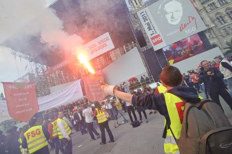Ein Gewerkschafter mit einer Pyro-Fackel bei einer 1.Mai Demo