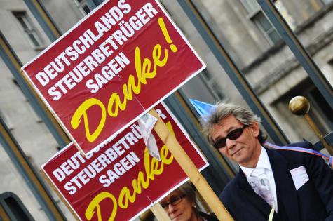 Ein Teilnehmer auf einer Demo gegen Steuerhinterziehung in Deutschland