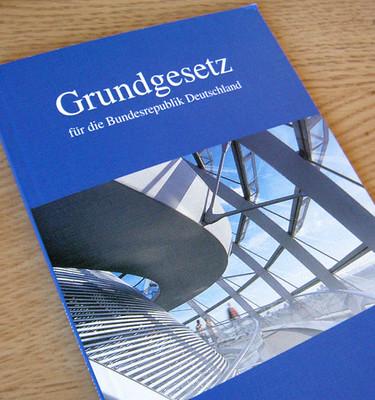 Das deutsche Grundgesetz in Buchform auf einem Tisch liegend