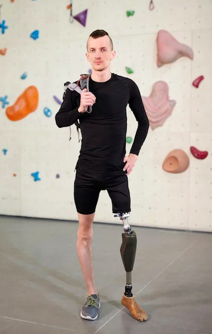 Mann mit einem Bein in Kletterhalle