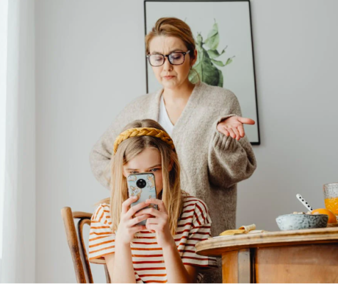 Mutter spricht mit Kind, das am Handy ist