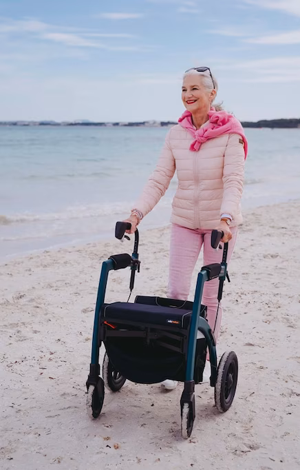Frau mit Rollator am Meer