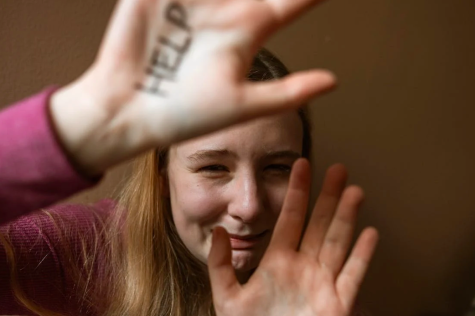 Frau h&auml;lt sch&uuml;tzend die H&auml;nde vors Gesicht