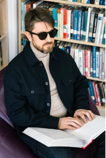 Blinder Mann liest in Bibliothek