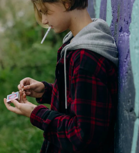 Junge zündet sich Zigarette an