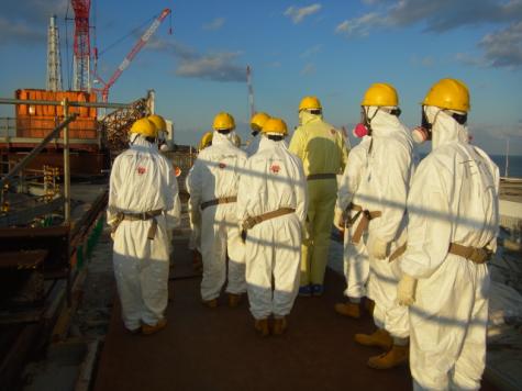 Eine Gruppe Wissenschaftler in Schutzanz&uuml;gen auf dem Gel&auml;nde von Fukushima
