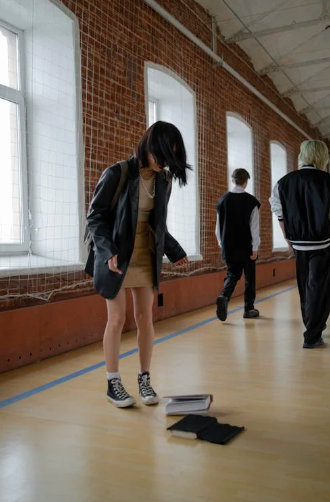 M&auml;dchen wird angerempelt, B&uuml;cher fallen runter